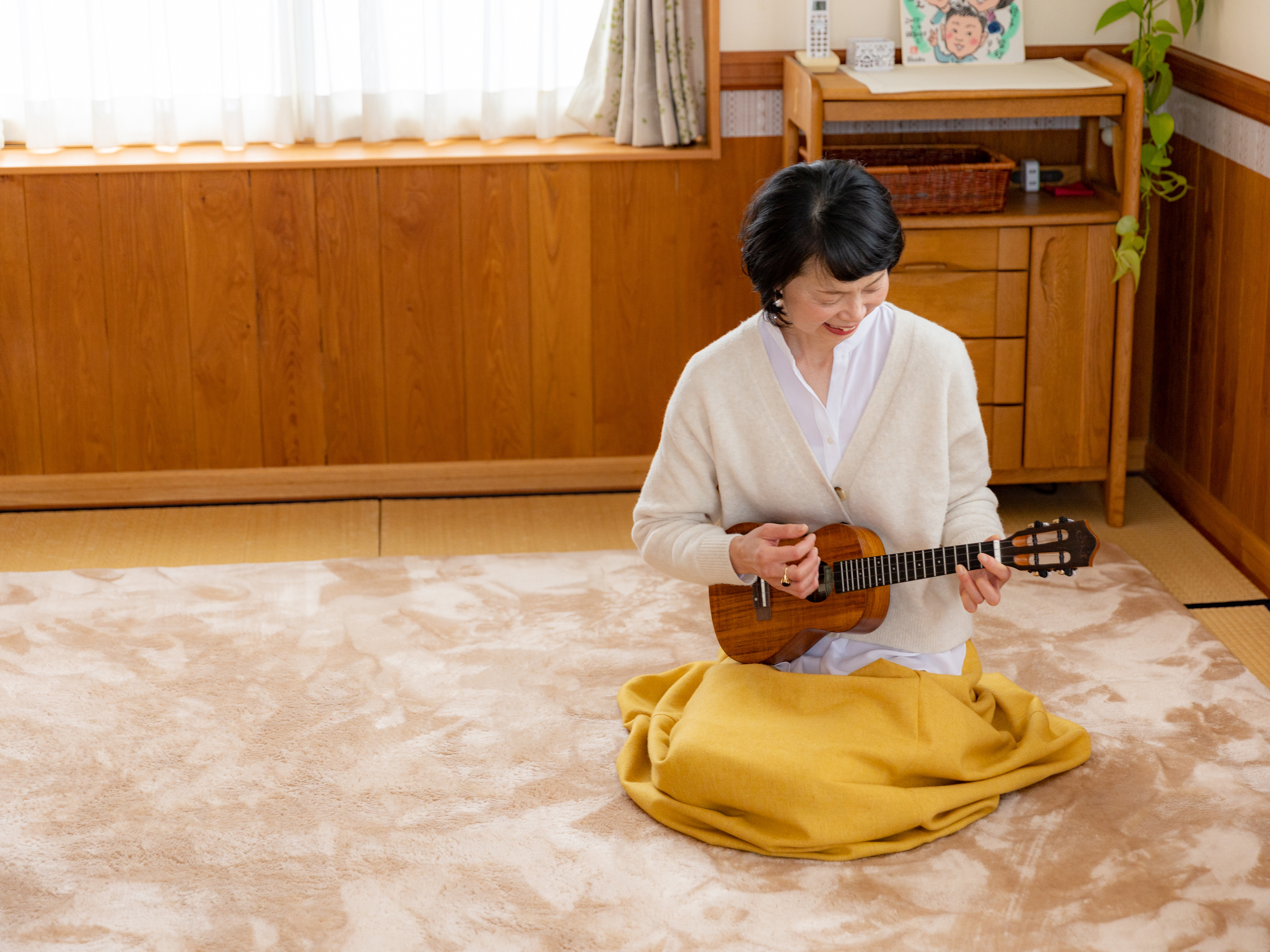 笑顔でウクレレを弾くのんのん